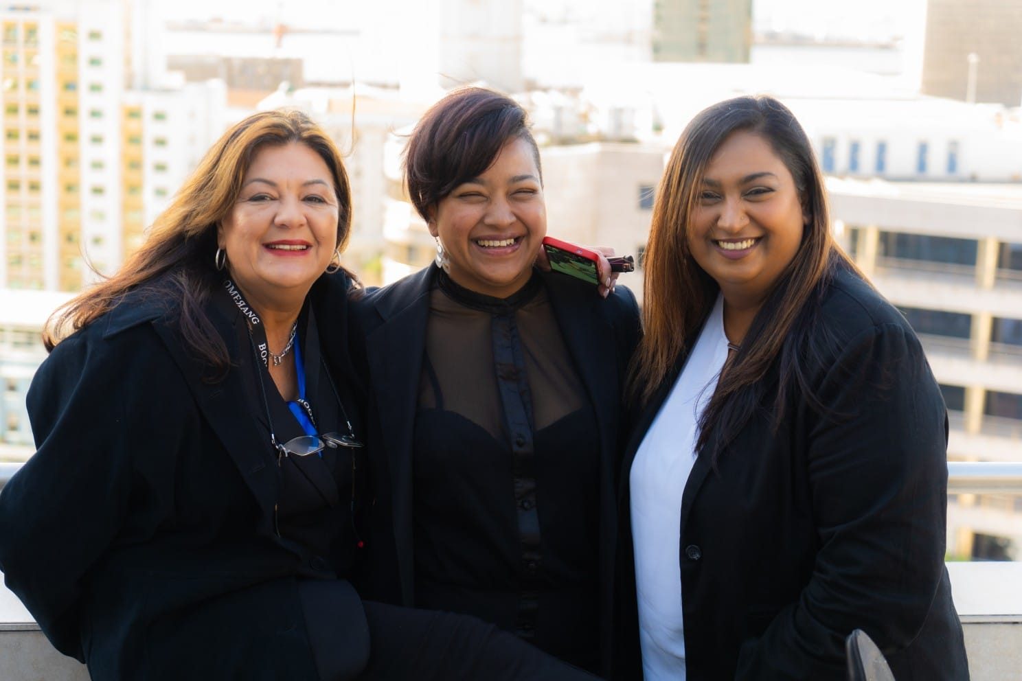 three ladies of Boomerang Management team smiling in photo. Left to right, Jacqueline, Dorianne & Natasha.