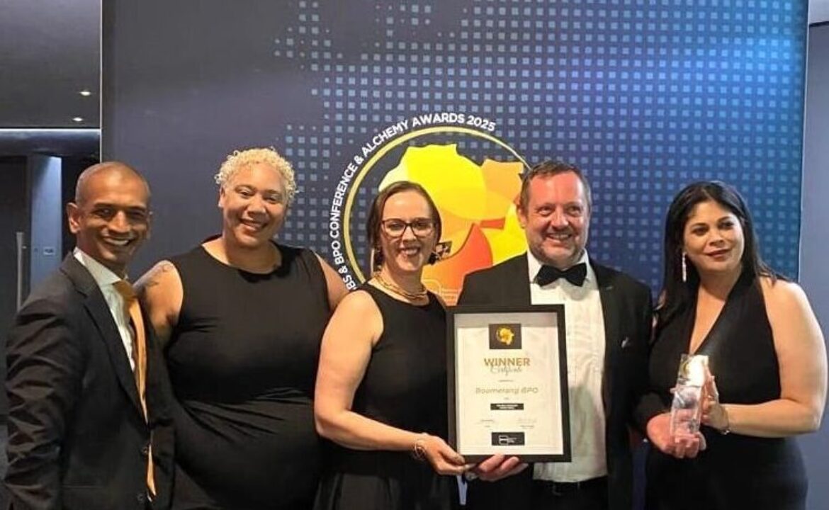 Boomerang Team of 5 standing with top BPO Operator Award in front of a sign with event name