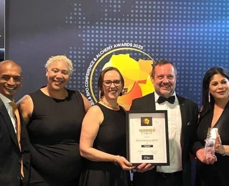 Boomerang Team of 5 standing with top BPO Operator Award in front of a sign with event name